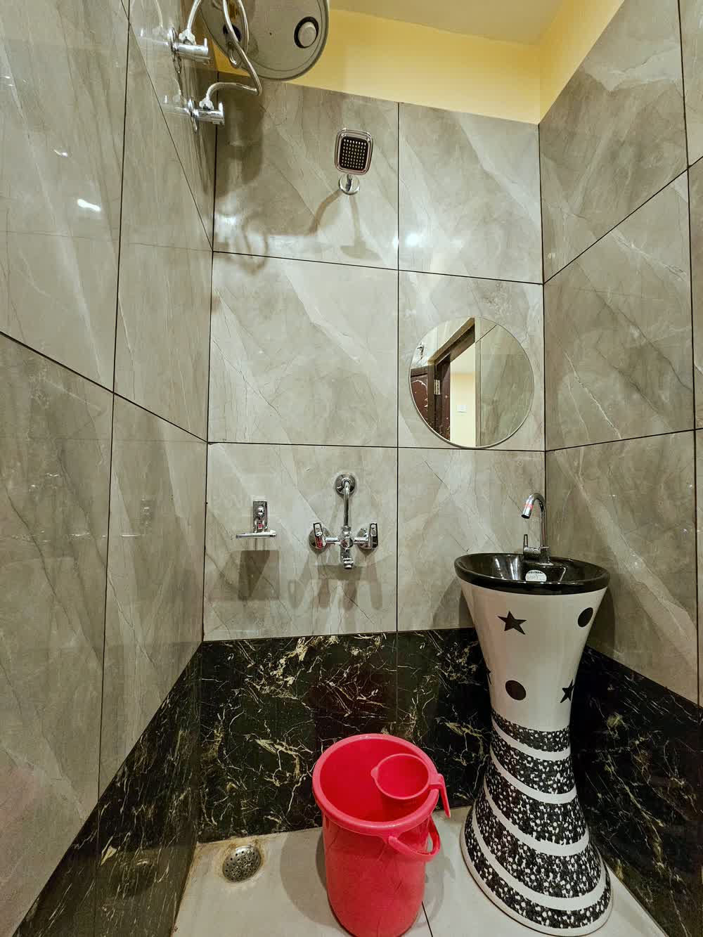 A guest bathroom finished in marble, with a basin and a mirror.