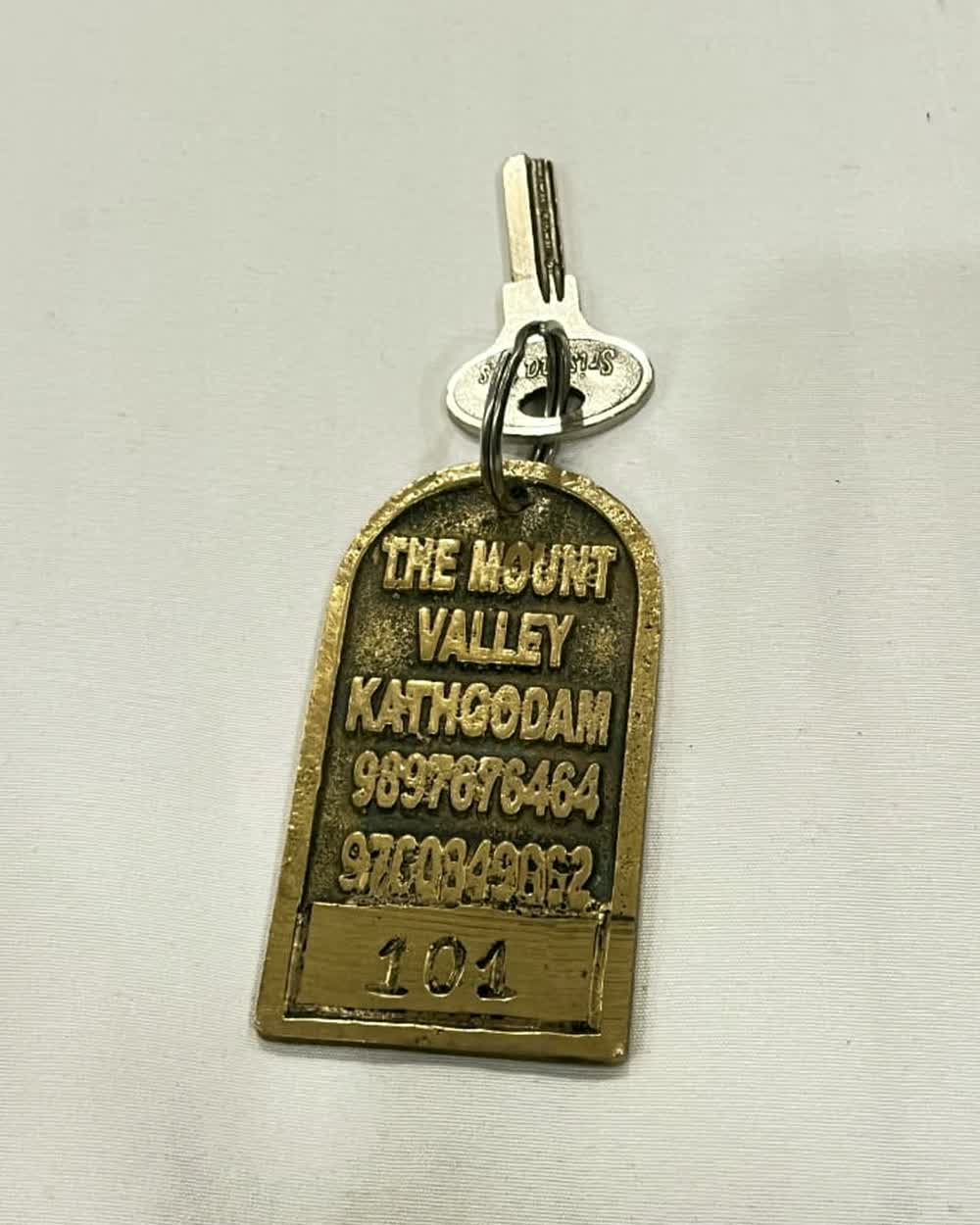 The brass room-key fob, stamped THE MOUNT VALLEY KATHGODAM.